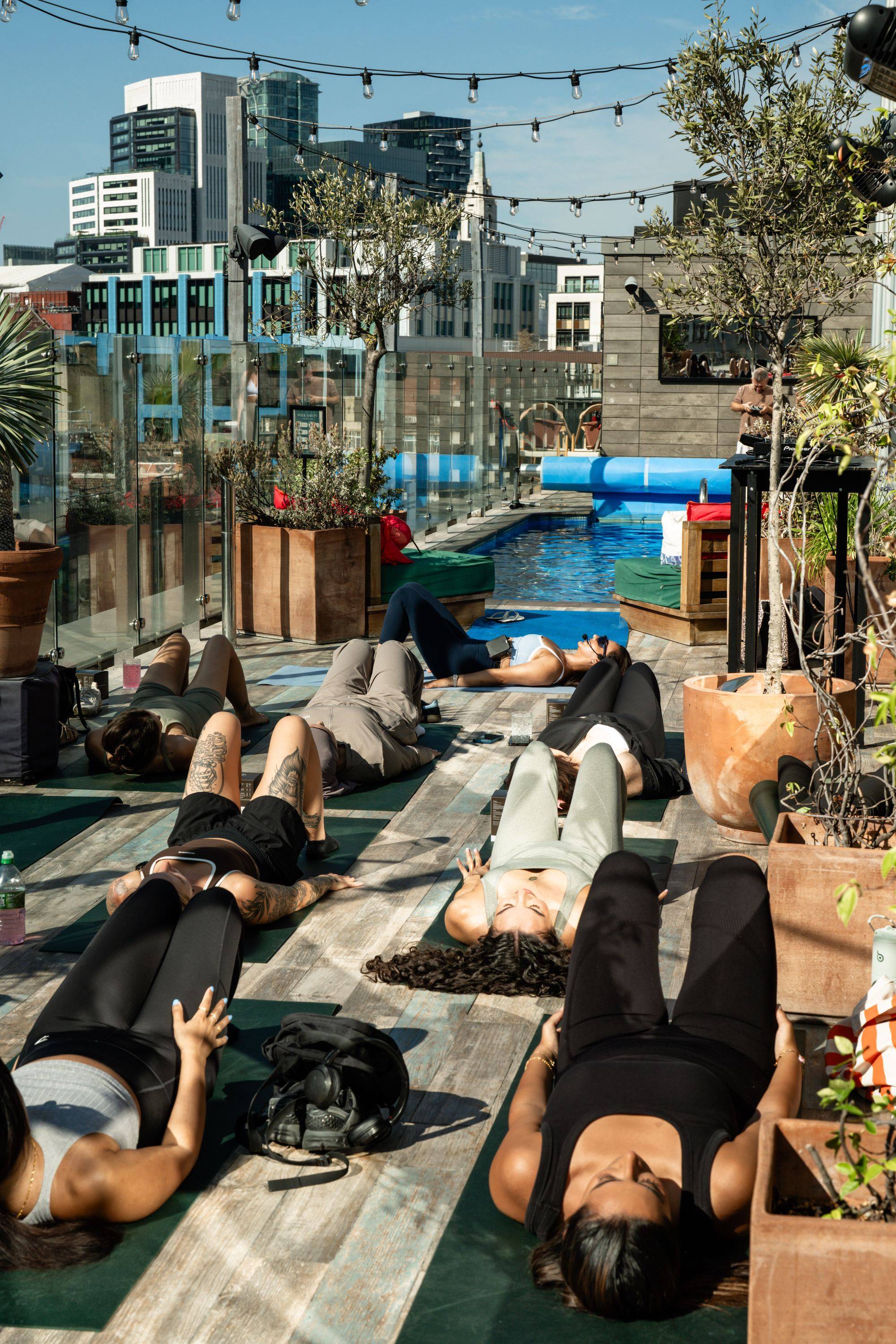 Sunrise pilates beside the rooftop pool, London skyline beyond